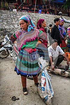 Flower hmong woman checking goods at the Bac Ha Market, Lao Cai, Vietnam